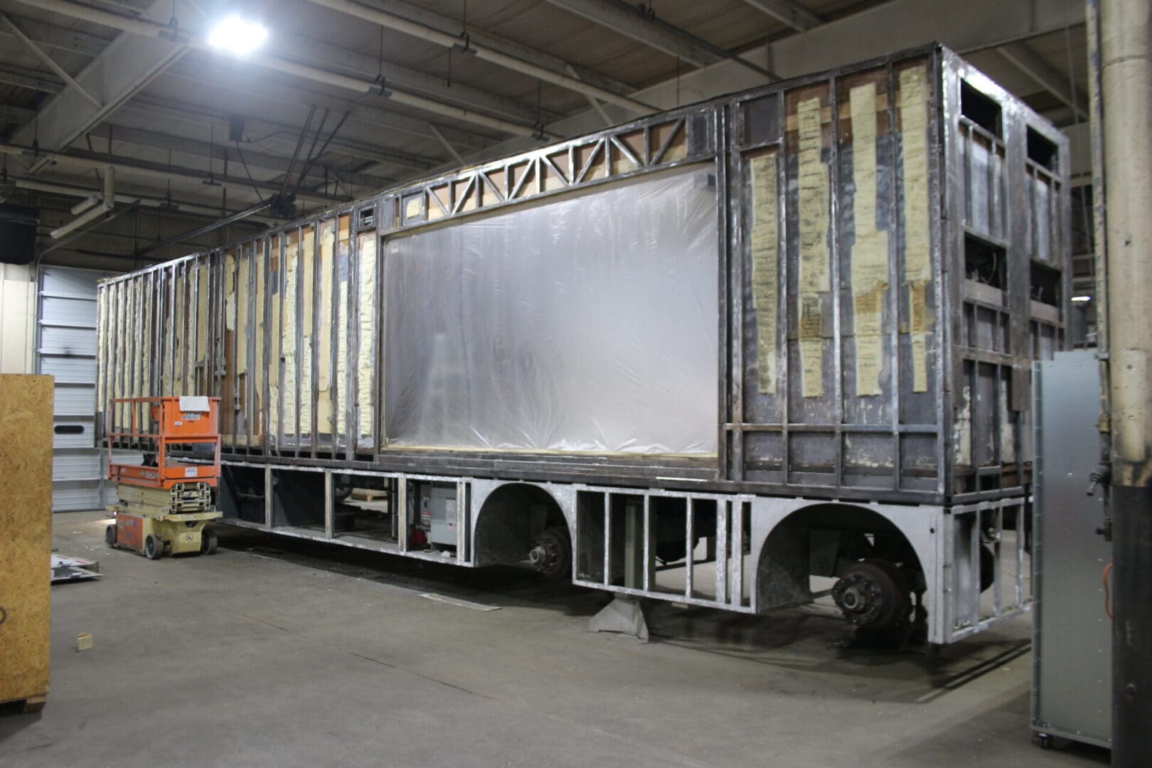 A large truck in a warehouse with a metal frame.