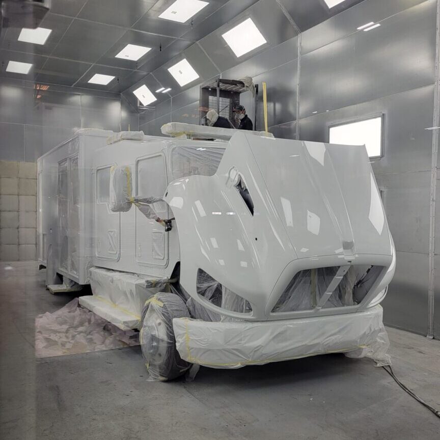 A white truck in an industrial setting with lights.