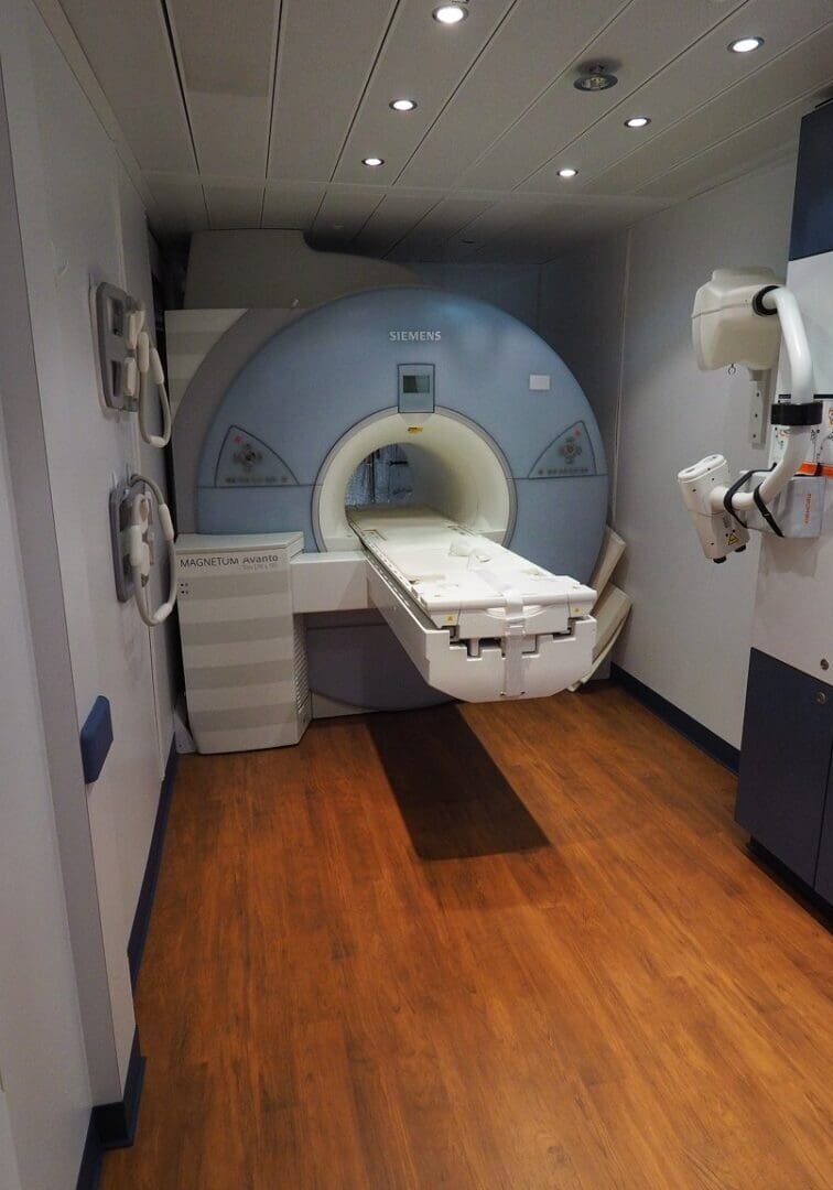 A room with a mri machine and wooden floors