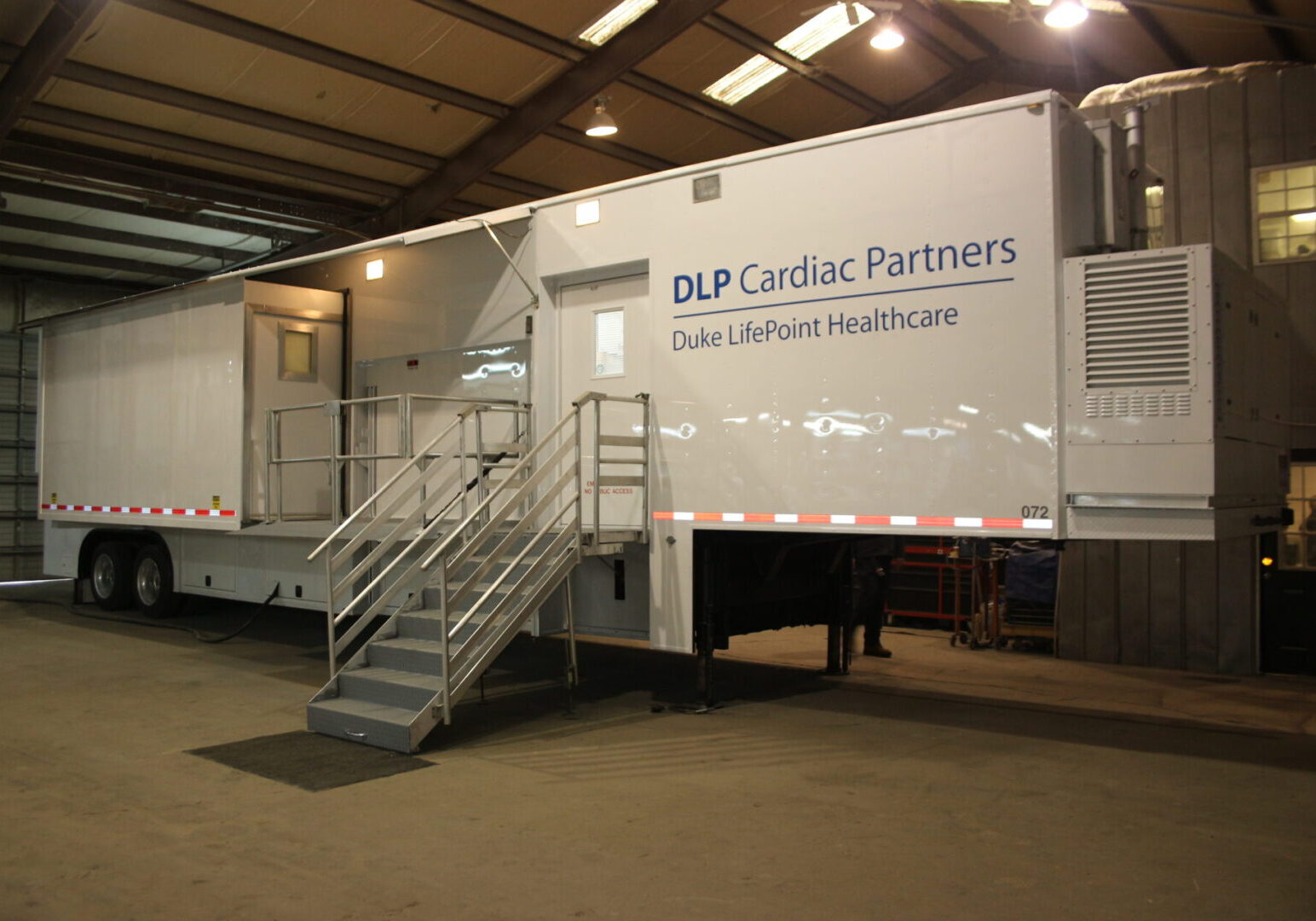 A large white trailer with stairs leading to it.